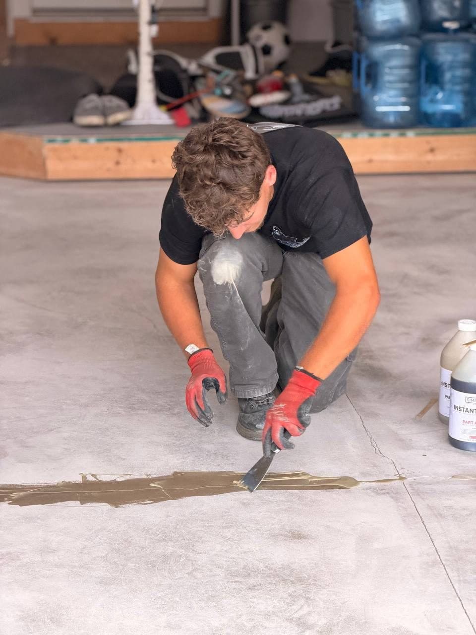 Crew member trowelling polyurea basecoat onto a prepped slab